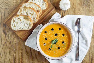 Vegetarian autumn pumpkin and carrot soup with cream, seeds and cilantro micro greens. Comfort food, fall and winter healthy slow food concept. High quality photo