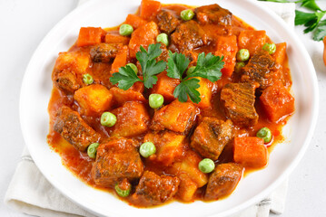 Fototapeta premium Beef stew with potatoes and carrots in tomato sauce