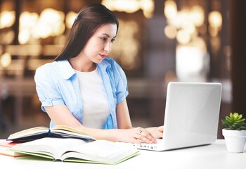 Positive woman working on laptop computer