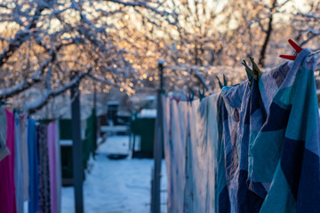 Frozen bed linen on the street in winter. Snow on washed clothes