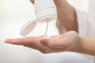 Close up woman hands squeeze cream or lotion drop on hand before apply on her face. Self care of...