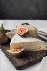 cheese and figs on a wooden board