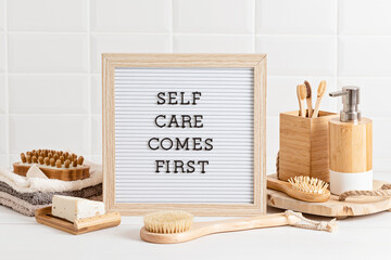 Fototapeta na wymiar Bathroom styling and organization. Letter board with text Self care comes first. Organic lifestyle and skin care products.