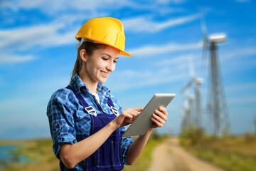 Young engineer working on windmills background.