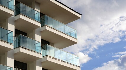 modern building with glass balconies against cloudy sky