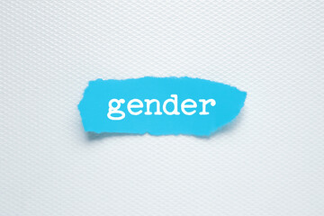 Gender wiht torn blue paper on a white background