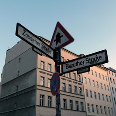 berlin street signs in the falling sun - obrazy, fototapety, plakaty