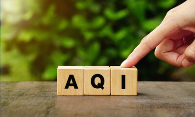 AQI Abbreviation of air quality index text on wooden cubes on nature background.     