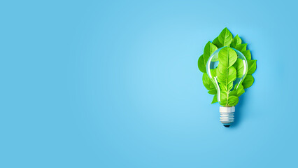 Green energy concept. Energy saving technology, light bulb with green leaves on blue background Space for text on the left