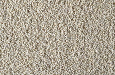 White hulled sesame seeds background and texture 