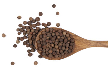 Allspice, pimento spice, Jamaican pepper pile in wooden spoon isolated on white, top view