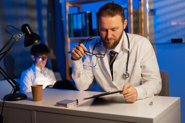 Adult and young doctors working during shift night. Medicine and healthcare concept.