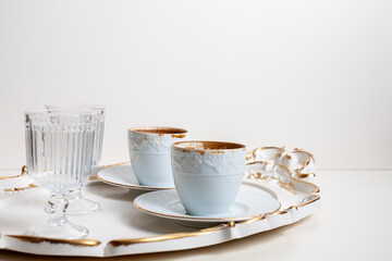 cups of coffee and empty glasses in tray on table