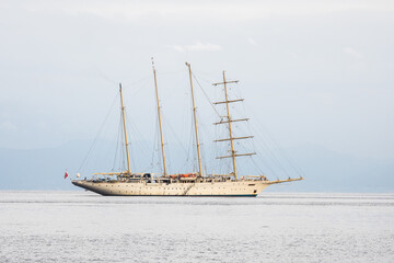 Fototapeta na wymiar Four masted sailing cruising ship on sea
