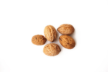 Walnuts in shell isolated on white background. A pile of delicious and healthy whole walnuts, isolated on a white background. Healthy food concept.                   