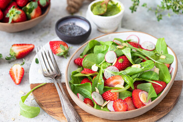 Spinach salad with strawberries, almond and poppy.