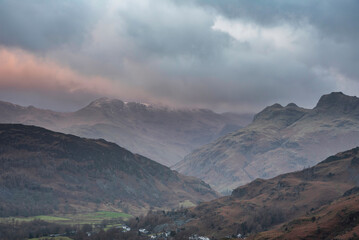 Stunning Winter sunrise landscape view from Loughrigg Fell towards Langdale Pikes and Pike O'Blisco in the Lake District