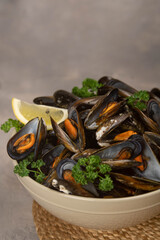 Delicious seafood mussels with with sauce and parsley. Lemon slices. Clams in the shells.