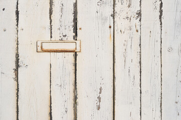 Wall made in old wooden beams fixed in vertical position, with a mail box, everything painted in white color, reliefs