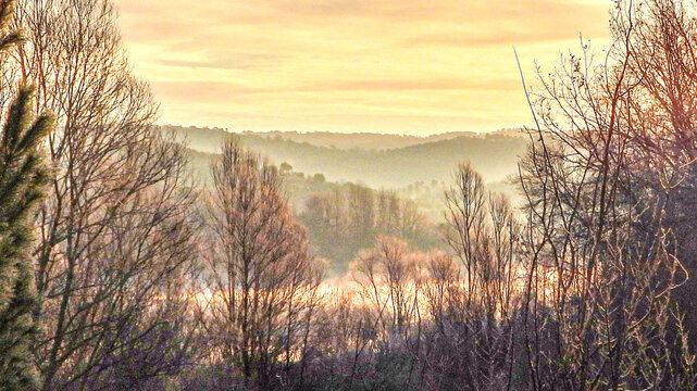 Spectacle de la nature avec un paysage et un lever de soleil hivernal au bord du lac de Saint Cassien dans le Sud de la France avec  une for&ecirc;t et de la brume