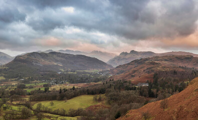 Stunning Winter sunrise landscape view from Loughrigg Fell towards Langdale Pikes and Pike O'Blisco in the Lake District