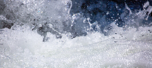 Drops of water, splashing and bubbling waterfall as a background. Foam party or laundry. The concept of freshness of soft drinks.