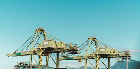 The capture of two massive yellow container handling cranes at work at the bustling dockside of Rio...