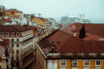 Fototapeta premium A capture of the charming beauty of the historic Portuguese architecture from the rooftops. And in the background a cruise moored in the Rio Tejo, adding to the picturesque atmosphere of the city