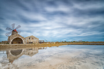 Windmill reflected on the water of the Trapani salt pans, Sicily