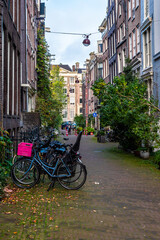Bicycles parked in the narrow streets of Amsterdam in the Netherlands. Bicycle with pink basket in an alley