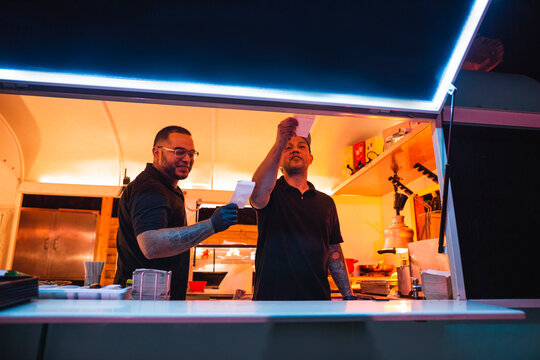 Hispanic workers preparing orders in a food truck