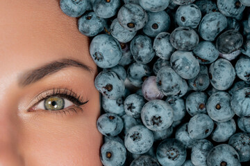 Half woman face in fresh ripe berries - blueberries, organic bilberry plant
