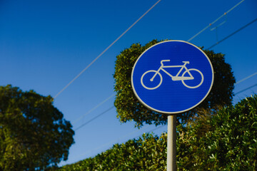 Road car round blue sign.  Cyclists