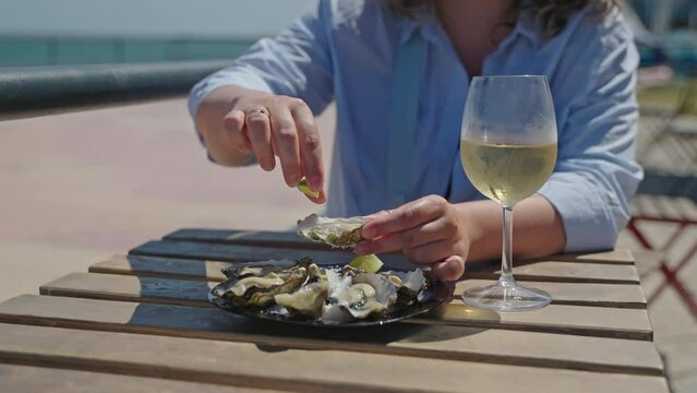 Woman is going to eat oysters with lime juice