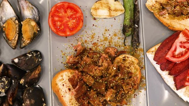 Turkish style appetizer street food stuffed mussels called midye dolma with lemon , Turkish kokorec and sucuk. High quality 4k footage