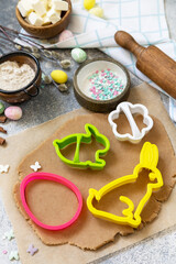 Easter baking ingredients background. Flour, eggs, milk, sugar, butter and kitchen utensils for baking on a stone table.