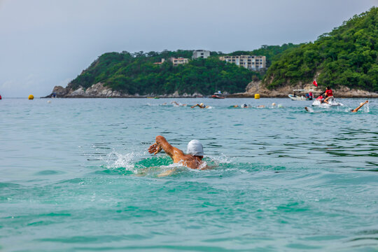 Triathlete starting the swim in the Huatulco bay - Mexico. Open water swimmer on the ocean