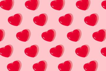 Valentines day creative pattern with bright red hearts on pastel pink background. 80s or 90s retro fashion aesthetic love concept. Minimal romantic idea.