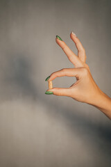 hand with pill, isolated on gray background