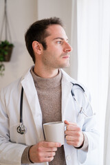 Young doctor with cup of coffee