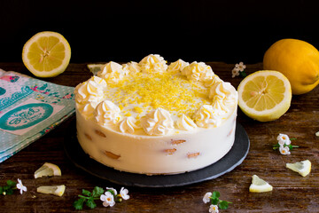 Tarta fría de limón y galletas en bandeja de pizarra, mesa de madera y fondo negro