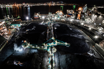 Rotary shovel at coal pile, bulk shipping terminal, silos, grain elevators, freight vessels, North...
