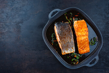 Traditionelles japanisches Lachs Teriyaki Filet serviert als Draufsicht in einer Nordic design Pfanne mit Textfreiraum links