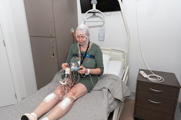 Middle aged woman measuring brain waves, examining polysomnography in sleep lab