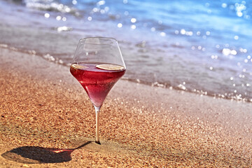 Wine glass with a cocktail by the sea.