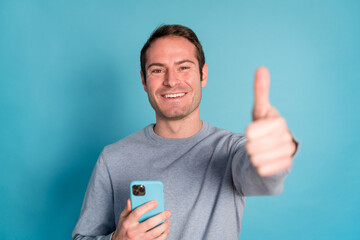 Cheerful man with smartphone doing the OK sign