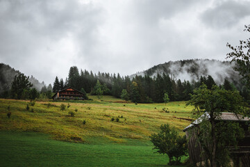 Fototapeta premium Wooden hut in the alps with mountains in the background Panorama