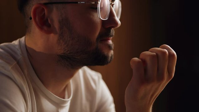 A man bites his nails in the evening