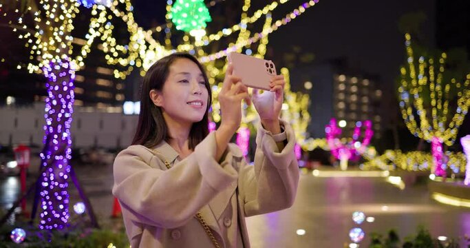 Woman use mobile phone for take photo at night