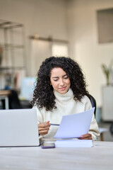 Young latin business woman manager accounting analyst checking bills, analyzing sales statistics...
